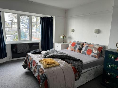 een slaapkamer met een bed met een deken erop bij Central City Centre 3 bedroom home Private Parking in Plymouth
