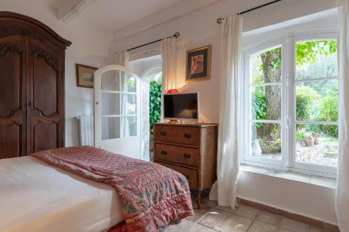ムージャンにあるLe MAS des BANYONSのベッドルーム(ベッド1台、テレビ、窓付)