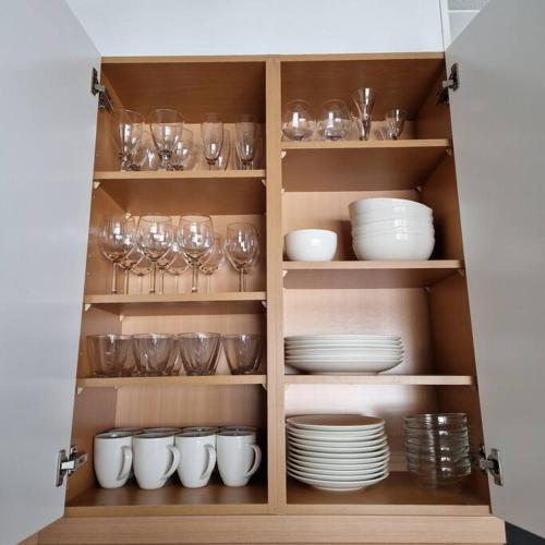 a cabinet filled with dishes and glasses and plates at Tahko Apartment Kehtola, Tahkovuori in Tahkovuori