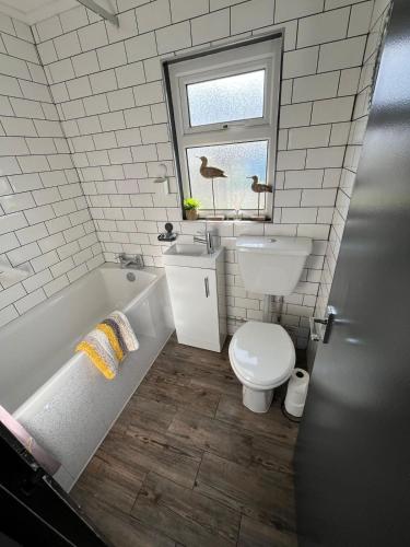 a bathroom with a toilet and a sink and a tub at 44 Sundowner Hemsby in Great Yarmouth