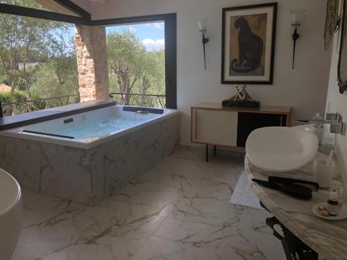 une grande salle de bain avec une baignoire et un lavabo dans l'établissement Le MAS des BANYONS, à Mougins