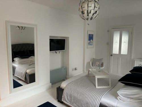 a bedroom with a bed and a large mirror at Jurassic Hideaway in Budleigh Salterton