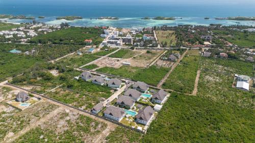 an aerial view of a village with houses and the ocean at Rafiki Tamu Residential Resort in Watamu