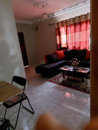 a living room with a couch and a table at Résidence beau-lieu in Awaé I