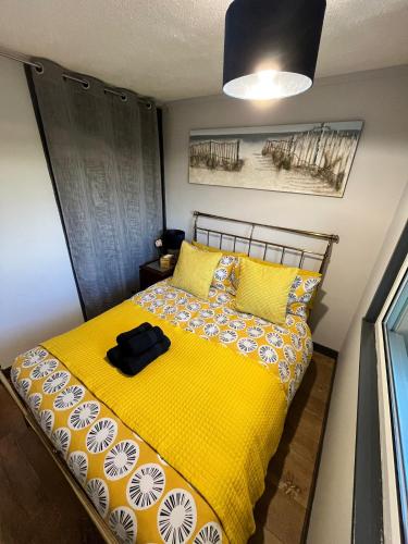 a bedroom with a yellow bed with yellow pillows at 44 Sundowner Hemsby in Great Yarmouth