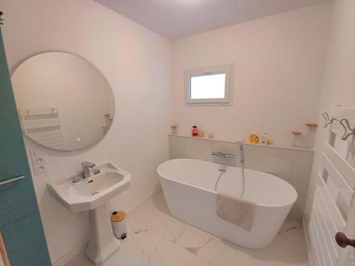 Ranndi Terras - Yourhosthelper conciergerie في لانستير: حمام مع حوض ومغسلة ومرآة