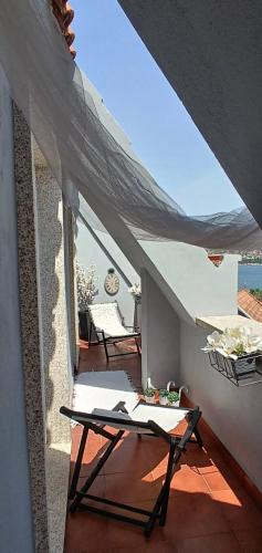 a balcony of a house with a table and chairs at Rincón del Mar Terrazas y vistas a la Ría de Vigo in Moaña