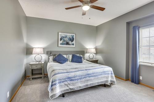 1 dormitorio con 1 cama con almohadas azules y ventilador de techo en Updated Omaha Condo - 15 Miles to Downtown!, en Omaha