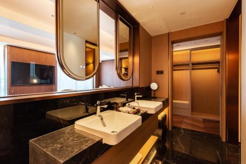 uma casa de banho com 2 lavatórios e um espelho em The Purple Horse em Pequim