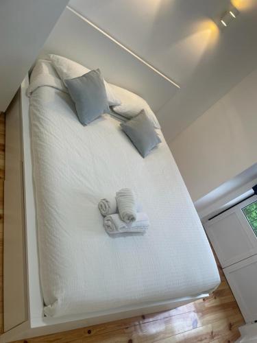 uma cama com duas toalhas e duas almofadas em Apartamento Pensamento Inédito 55 em Lisboa