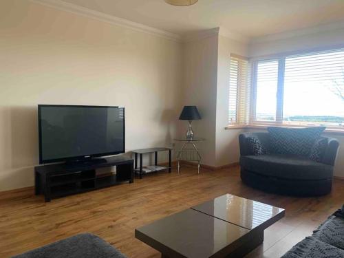 a living room with a large flat screen tv at Stornoway Holiday Let in Stornoway