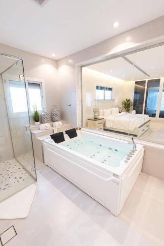 a large white bathroom with a large soaking tub at Tiffany Beach in Durat  Alarous