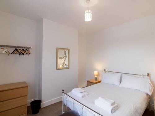 a bedroom with a white bed with towels on it at Church View - Pass the Keys in Ferryhill