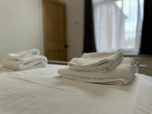 uma pilha de toalhas sentadas em cima de uma cama em Pass the Keys Church View em Ferryhill