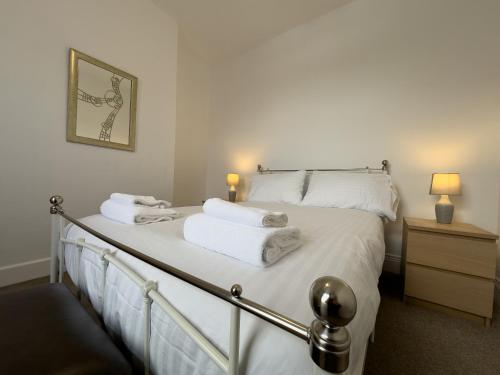 um quarto com uma cama com lençóis brancos e toalhas em Pass the Keys Church View em Ferryhill