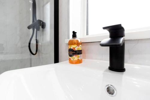 a bathroom sink with a bottle of soap and a faucet at Tithe Barn House in Stockton-on-Tees