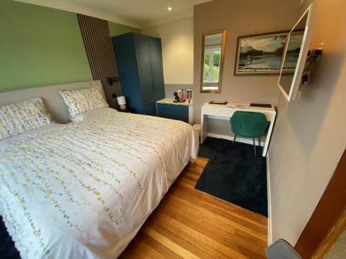 een kleine slaapkamer met een bed en een bureau bij Westwood - The B&B with a view in Cockermouth