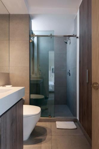 a bathroom with a toilet and a glass shower at Magnific 2BR in Cuauhtemoc in Mexico City