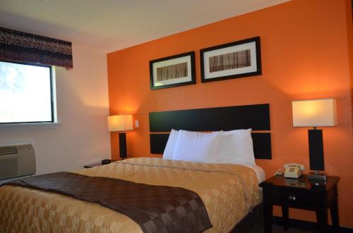 una camera d'albergo con letto a parete arancione di Enfield Inn a Enfield