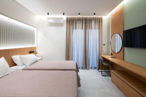 Habitación de hotel con 2 camas y espejo en Arocaria Apartments, en La Canea