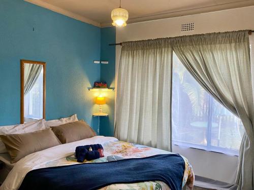 a bedroom with a bed and a large window at Horizon Green Guest House in Randfontein