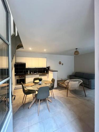 une cuisine et un salon avec une table et des chaises dans l'établissement Le beauplex, entre port et mer, à Dieppe