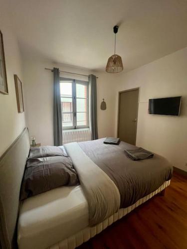 une chambre avec un grand lit avec une fenêtre dans l'établissement Le beauplex, entre port et mer, à Dieppe