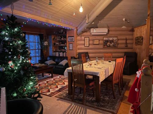 een eetkamer met een tafel en een kerstboom bij Log home near Santa in Rovaniemi