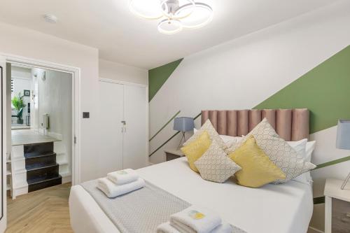 a bedroom with a white bed with colorful pillows at Stunning 2-Bed Apartment Fully Equipped - Clapham Junction - Battersea - 5 Minutes Train Station in London