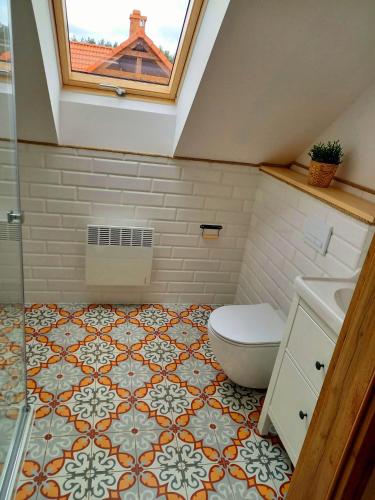 a bathroom with a toilet and a sink and a window at Ostoja Bukowo Prime in Borowy Młyn