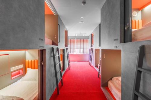 a room with several bunk beds and a red carpet at Circular House in Singapore