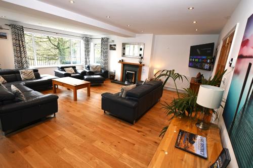 a living room with black furniture and a fireplace at Borrowdale View in Keswick