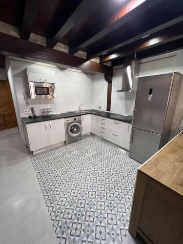 a kitchen with a washer and sink and a refrigerator at Apartamento dúplex en Sangüesa de 3 dormitorios y 2 baños in Sangüesa