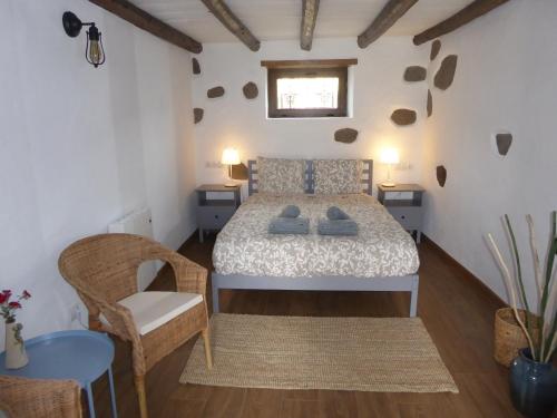 a bedroom with a bed and a chair in a room at La Casa de Arriba, private rooms in Teror, Gran Canaria in Teror