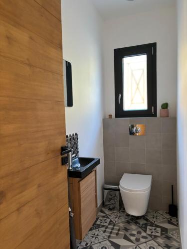 a bathroom with a toilet and a window at Appartement 2 personnes in Vico