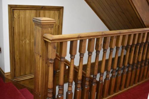 a wooden staircase with wooden railings in a house at Great Trethew Hotel - Self Catering Lodges - Bar & Restaurant in Liskeard
