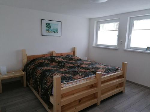1 dormitorio con 1 cama en una habitación con 2 ventanas en Fewo Halbe Tanne, en Schonach
