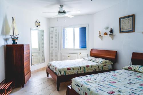 um quarto com 2 camas e uma ventoinha de tecto em Hermoso Departamento Casa Blanca remodelado 2 Habitaciones Wi-Fi Netflix em Same