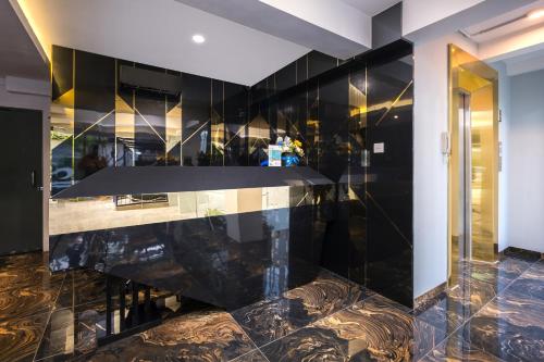 a kitchen with black walls and a marble counter at Gold Hotel Simpang Lima in Semarang
