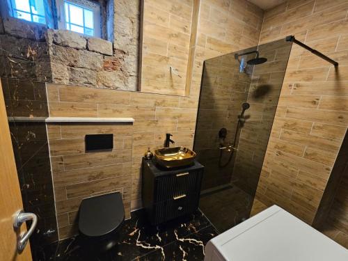 La salle de bains est pourvue d'un lavabo et d'une douche. dans l'établissement Apartment Antonio on the seafront with garden, à Kaštela