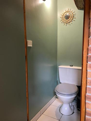 une salle de bain avec toilettes et un soleil sur le mur dans l'établissement Maison de Caractère, à Villers-sous-Saint-Leu