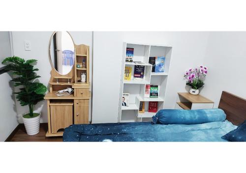 - une chambre avec un lit bleu et un miroir dans l'établissement Luxury Apartment - Charm Ruby, Di An, à Dĩ An