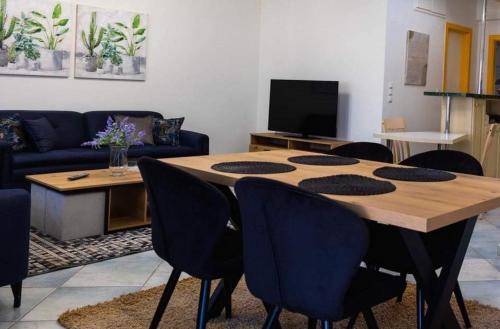 Orestiada的住宿－Kouros Cozy Home，客厅配有木桌和椅子