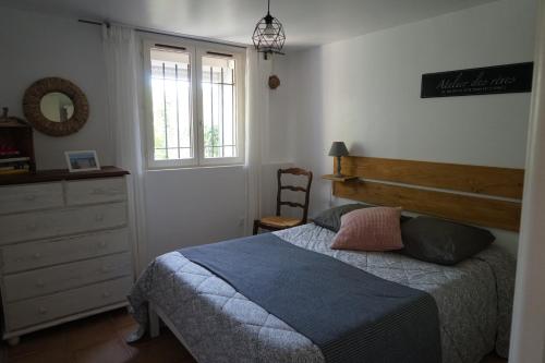 une chambre avec un lit, une commode et une fenêtre dans l'établissement Les cigales, à Hyères