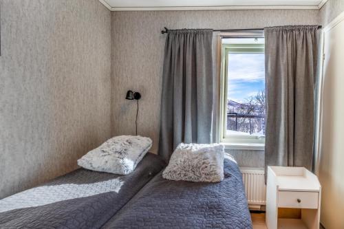 a bedroom with a bed and a window at Riekko Mökki in Kilpisjärvi