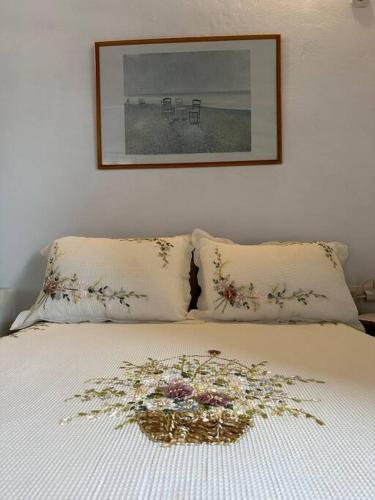 a bed with two pillows and a flower arrangement on it at Amalia beach apartment in Kokkari