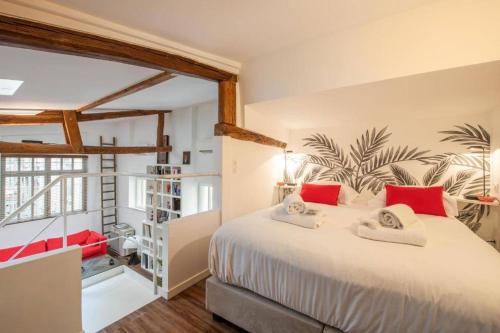 une chambre avec un grand lit blanc avec des oreillers rouges dans l'établissement Magnifique loft avec extérieur, à Paris