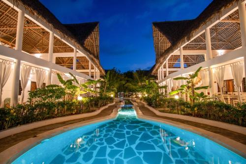 a swimming pool in the middle of a building at night at Rafiki Village in Watamu
