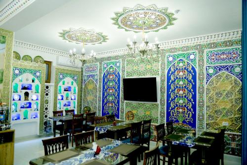 a dining room with brightly painted walls and tables at Meros Hotel in Bukhara
