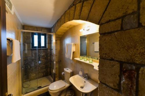 a bathroom with a toilet and a sink and a shower at Luxury Villa Nefeli in Stoupa, Private Pool & BBQ in Neokhórion